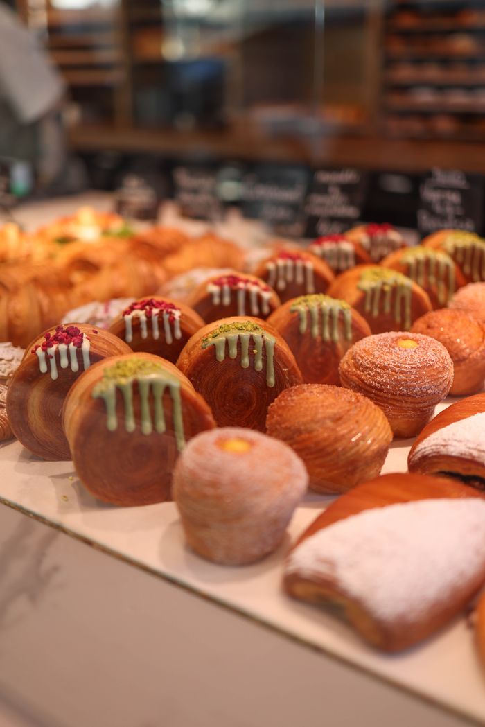 A delicious assortment of fresh pastries with various toppings displayed in a bakery.
